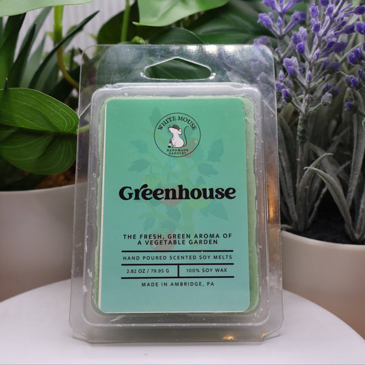 Packaged Greenhouse scented wax melts with plants in the background
