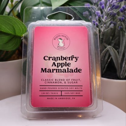 Cranberry Apple Marmalade wax melt packaging with plants in the background