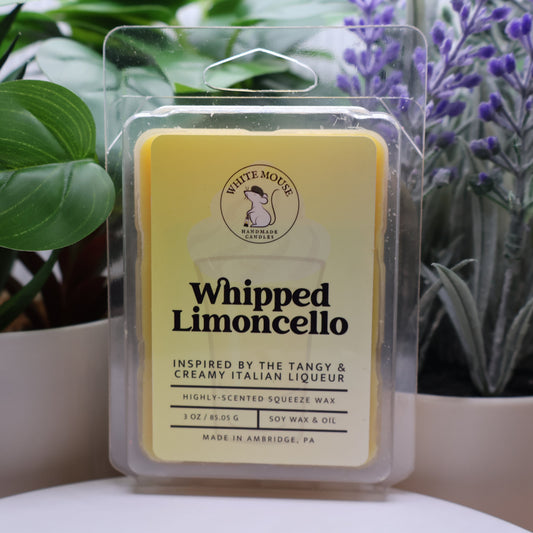 Packaged wax melt with 'Whipped Limoncello' flavor in front of plants